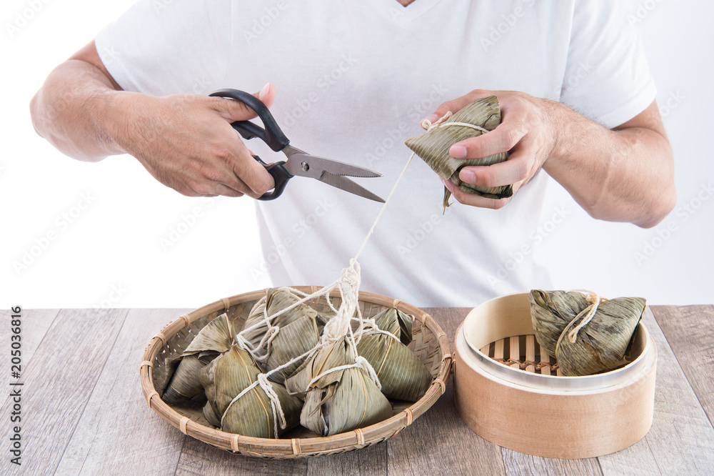 一个男人准备在端午节吃粽子或粽子，这是亚洲传统食品