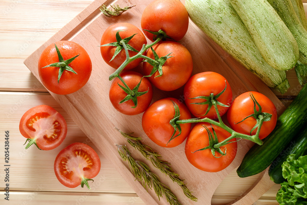 木质背景下新鲜成熟的西红柿和蔬菜的特写。俯视图。