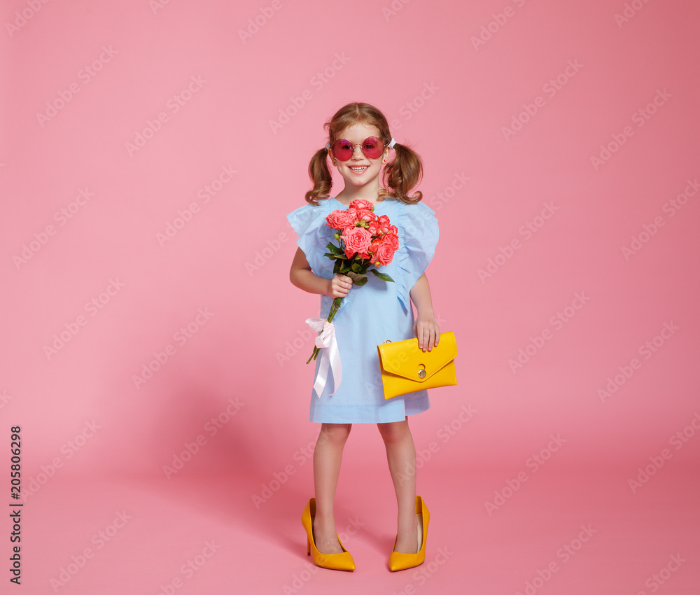 有趣的童女时尚达人，穿着彩色背景的大妈妈鞋。