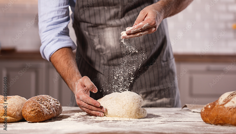 面包师的手是男性揉面团。