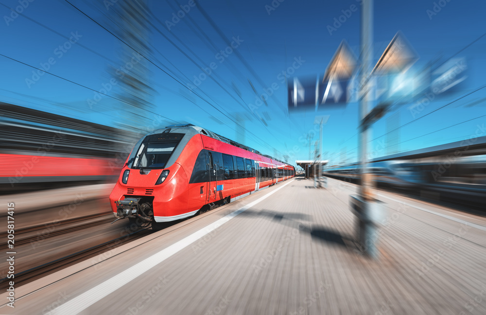明亮的日子里，高速红色列车在火车站上行驶。现代城际动车组