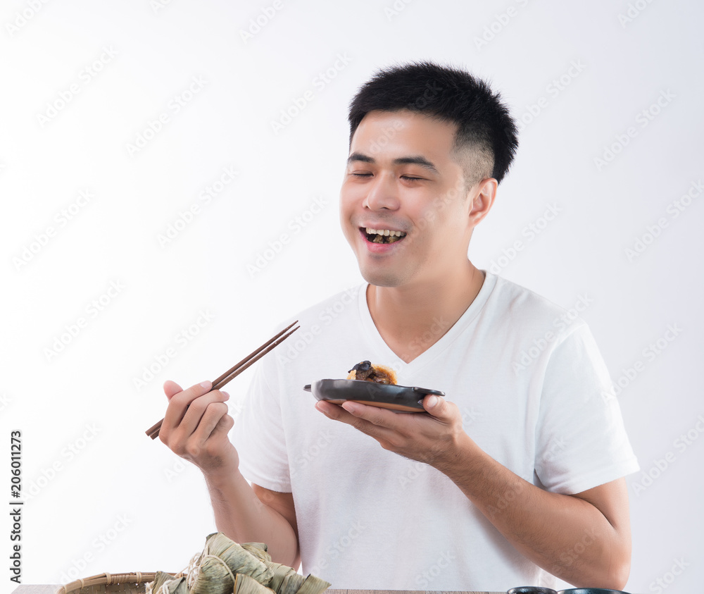 一个男人在端午节吃着美味的粽子，感觉很好吃，亚洲人