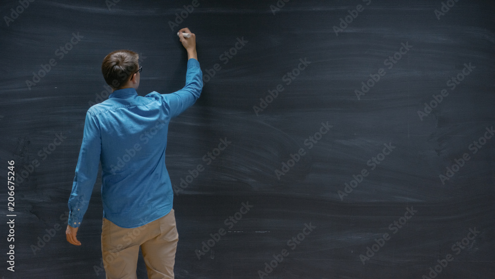 一个男人开始在黑板上写字的镜头。空黑板非常适合模板。