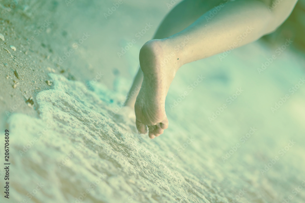 封闭式赤脚独自在海滩沙滩海水中行走