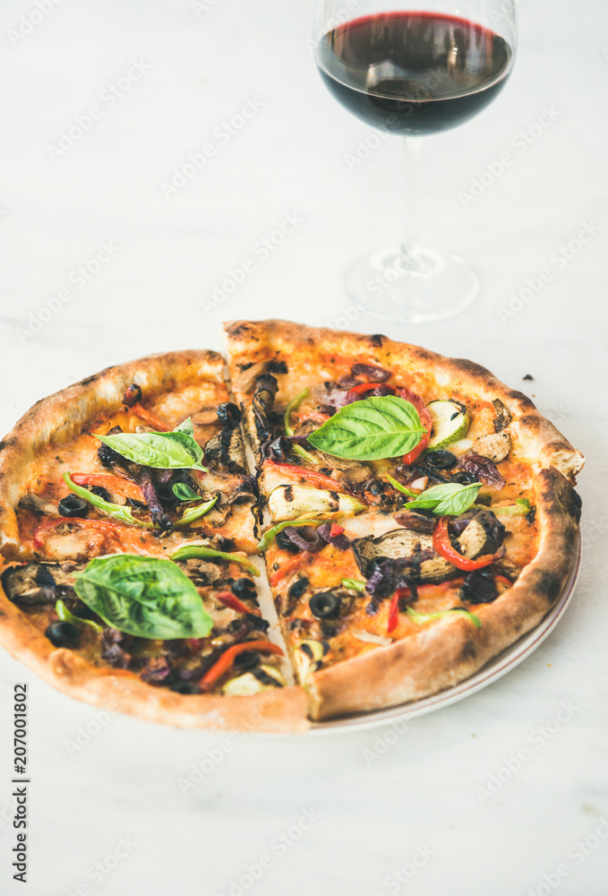 夏季晚餐或午餐。新鲜出炉的意大利素食披萨配蔬菜、新鲜罗勒和玻璃