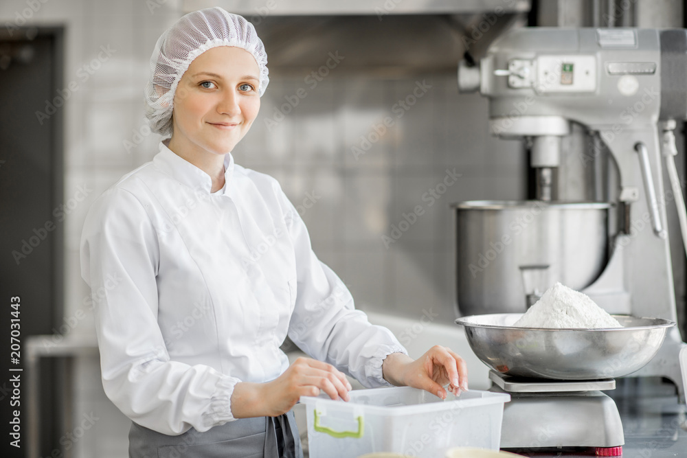 一位女性糖果师的画像，她在面包店为糕点配料称重。