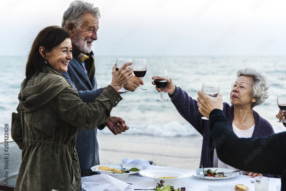 成熟的朋友在海滩上喝酒