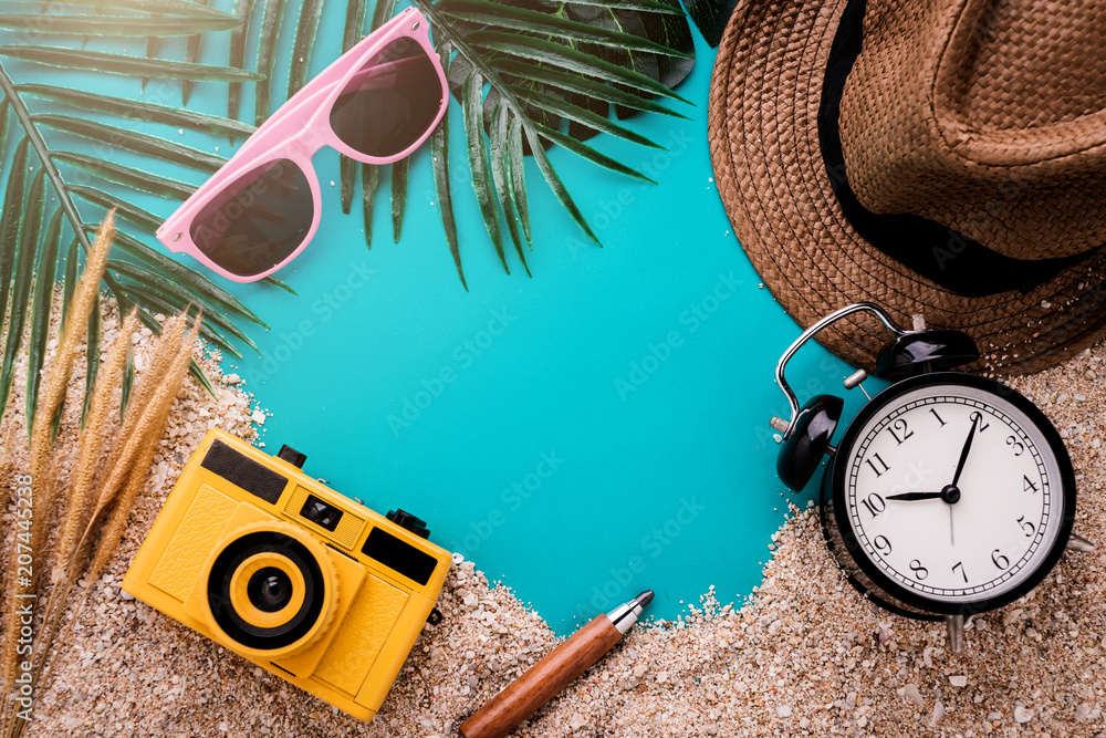 丰富多彩的暑假背景概念，沙滩纹理背景上有旅行用品