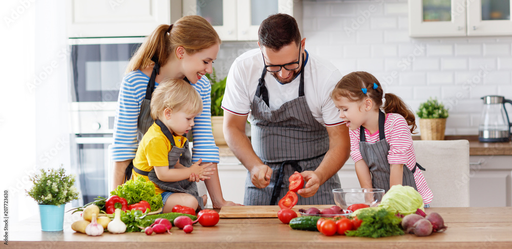 有孩子的幸福家庭正在准备蔬菜沙拉。