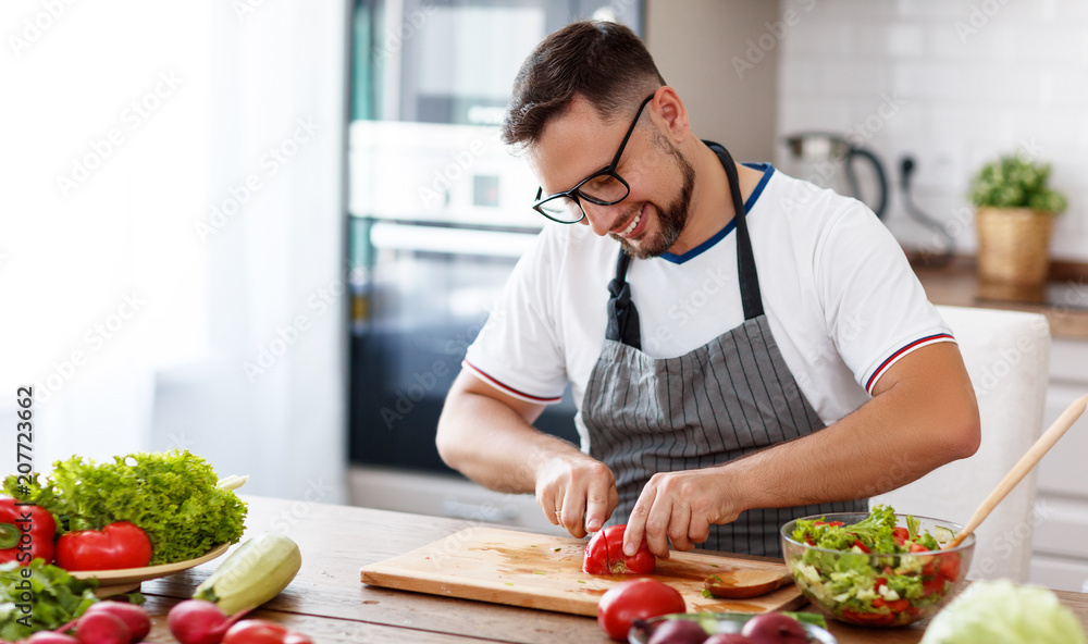 快乐男人在厨房准备蔬菜沙拉