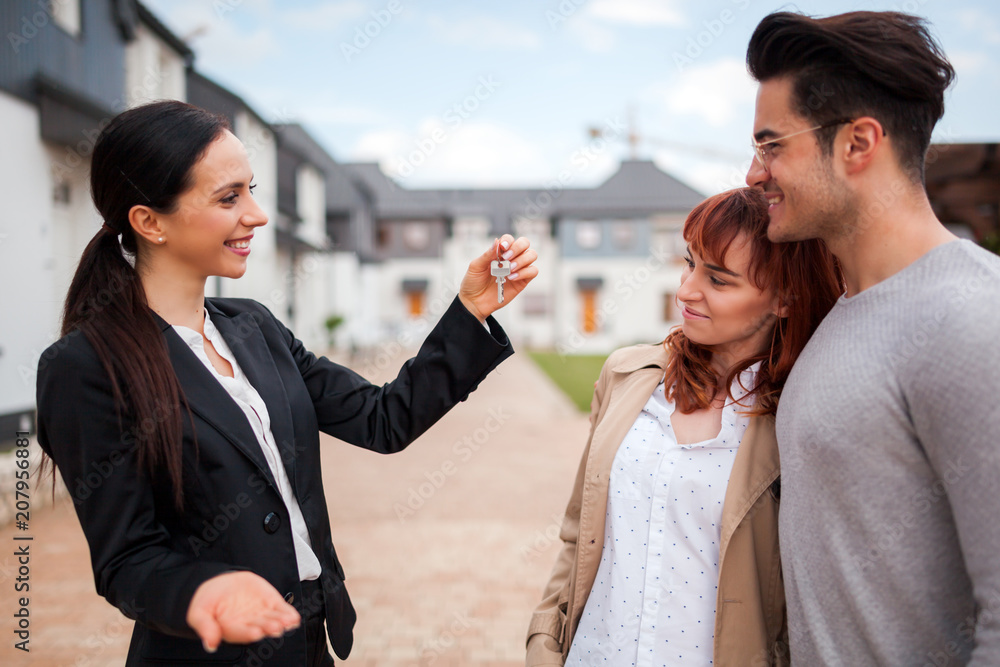 带钥匙的房地产经纪人为年轻的一对客户提供房子