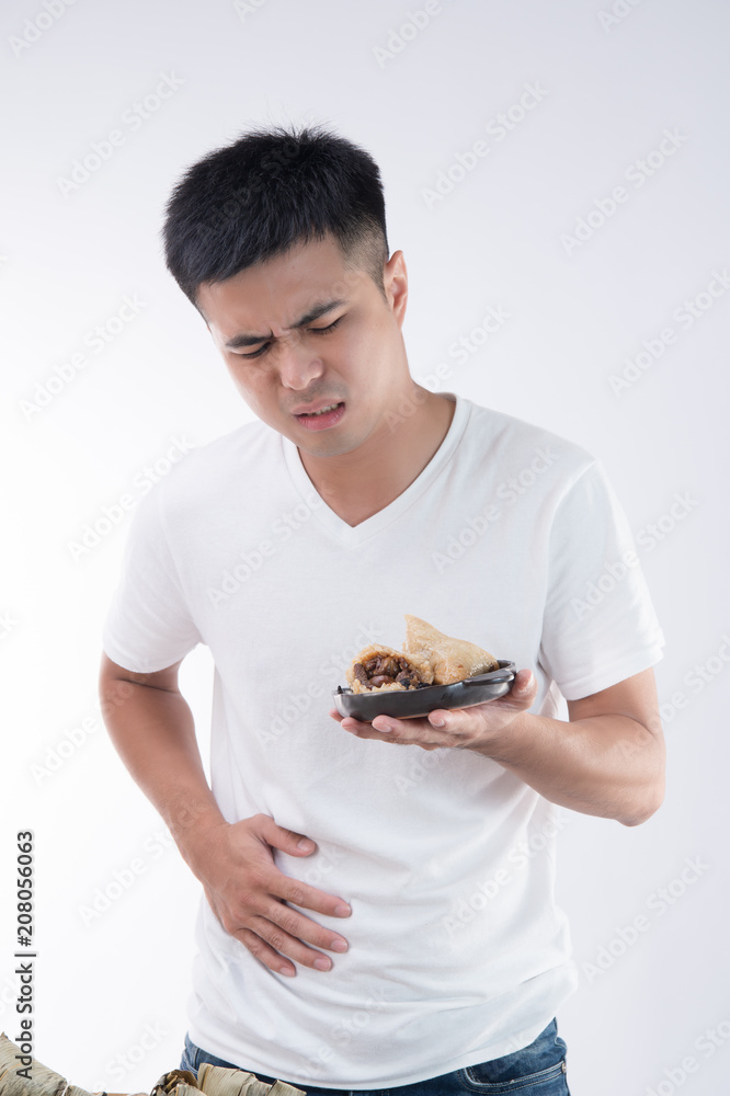 A man has a stomachache after eating delicious zongzi(rice dumpling) on Dragon Boat Festival, Asian 