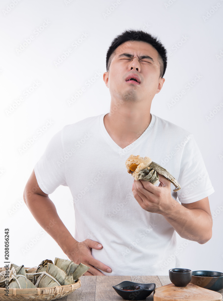 亚洲端午节，一名男子吃了美味的粽子后肚子疼