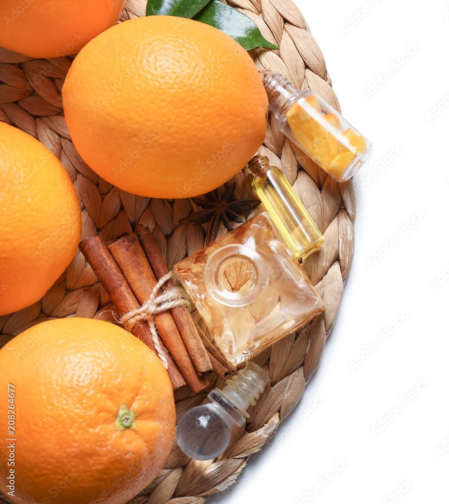 柳条垫上的柑橘精油和橙子瓶