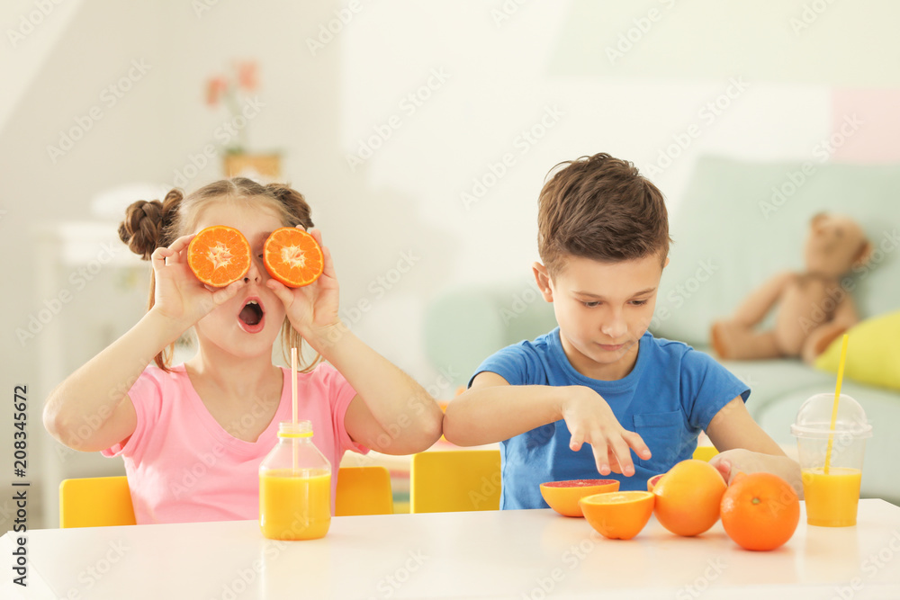 家里有柑橘类水果和果汁的有趣小孩