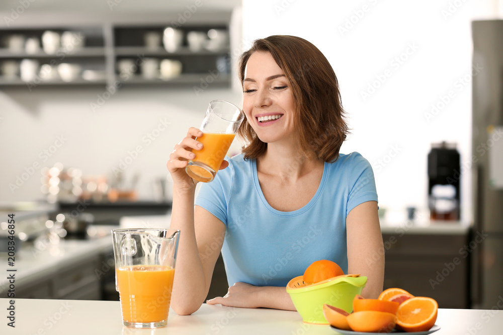 美女在厨房喝柑橘汁