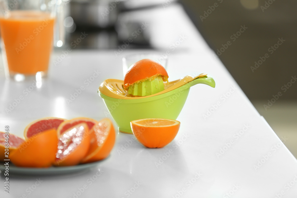 榨汁机，桌上有半个挤好的橙子