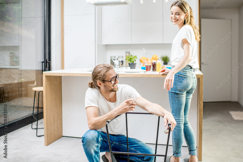 年轻可爱的夫妇在现代公寓的厨房里做家务组装新椅子