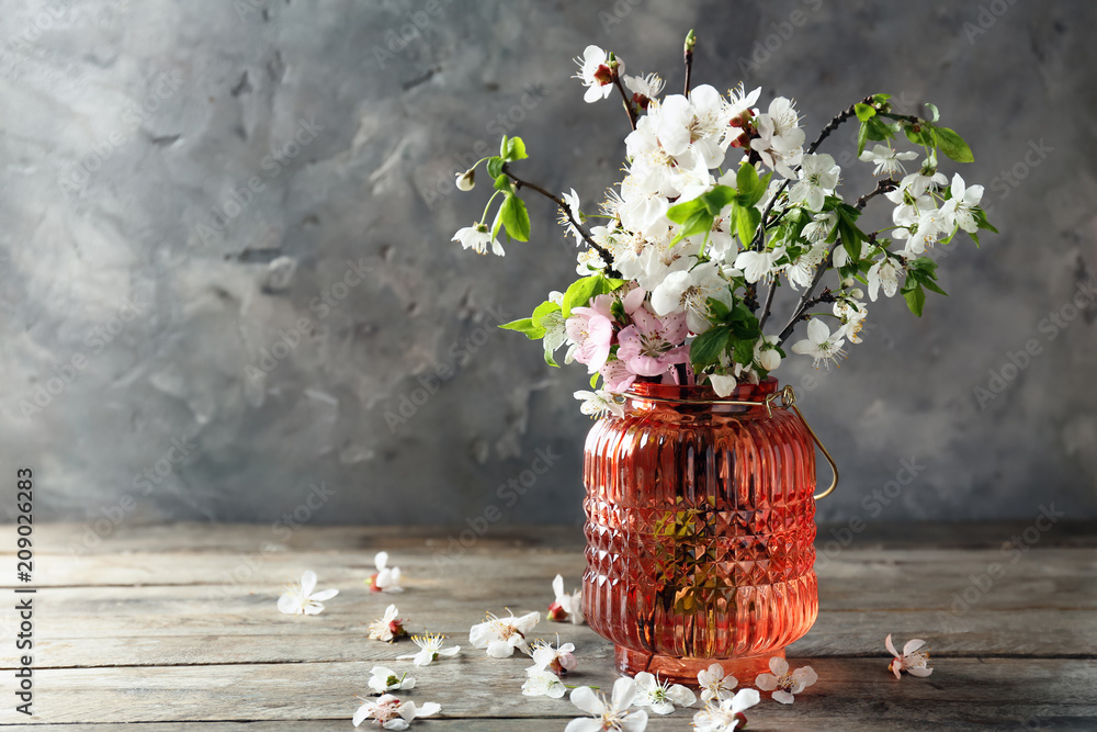 木桌上有美丽的开花树枝的花瓶