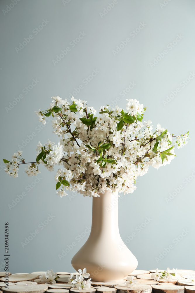 灰色背景下桌上有美丽花朵的花瓶