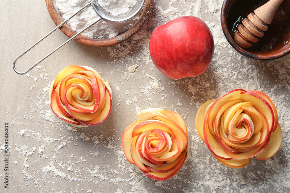 Raw rose shaped apple pastry on table