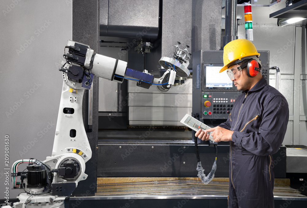 Maintenance engineer using digital tablet control automatic robotic hand with CNC machine in smart f