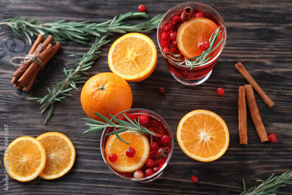 木桌上的肉桂、橙子和蔓越莓饮料