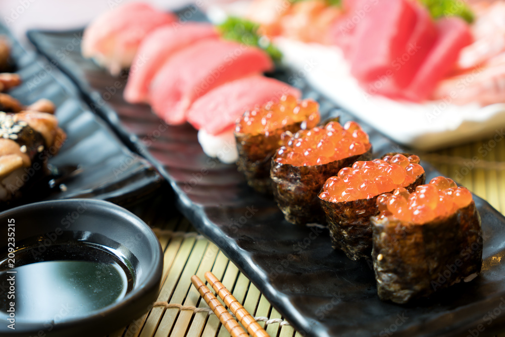 用筷子和酱油做寿司。餐厅里的寿司卷日本食物。三文鱼籽寿司套餐。
