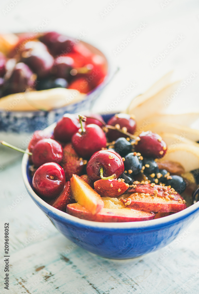 Healthy smoothie bowl with fresh fruit and berries, bee pollen and honey on blue table background fo