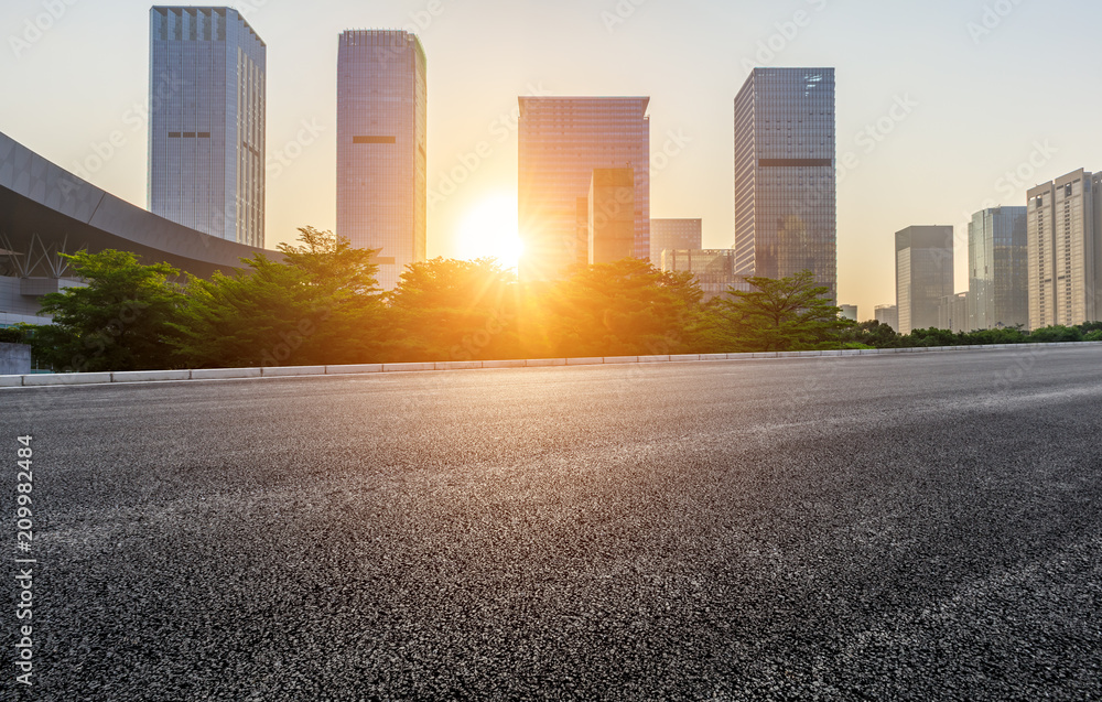 Empty asphalt road and modern city commercial buildings at sunrise in Shenzhen