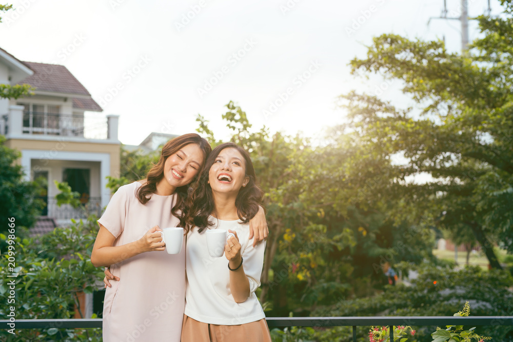 两个女人在屋顶花园喝咖啡放松