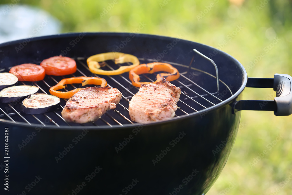 Cooking of juicy meat and vegetables on barbecue grill outdoors, closeup