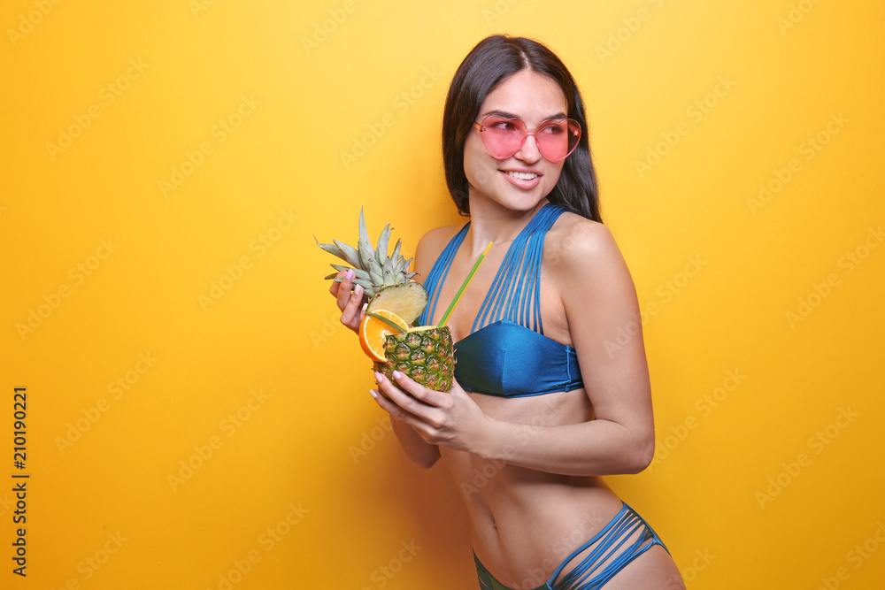 美丽的年轻女子穿着比基尼，背景是饮料和太阳镜