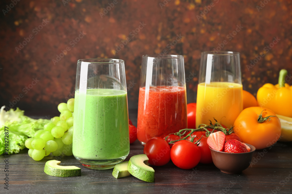 Glasses with fresh tasty smoothies and ingredients on table