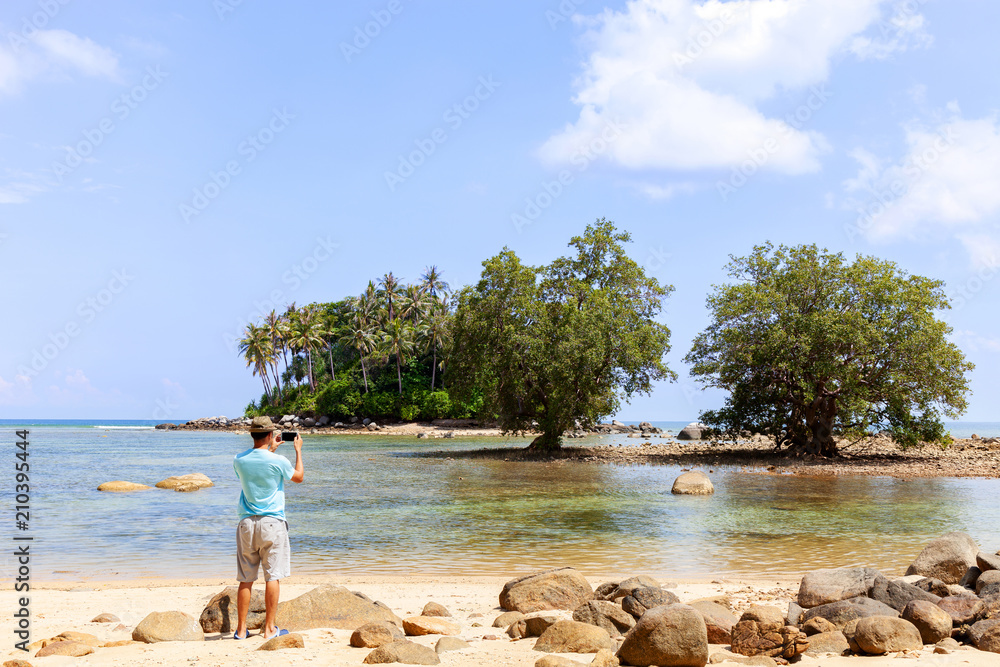 旅游者站着用智能手机拍照，普吉岛夏季美丽的小岛