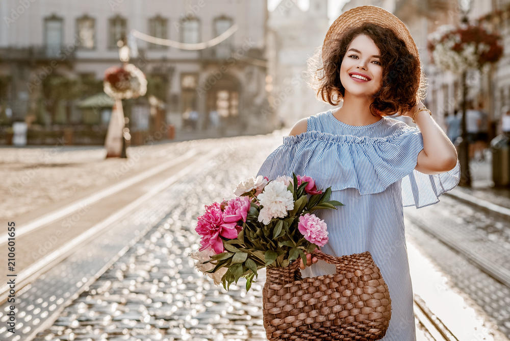 在欧洲城市的街道上摆出的年轻美丽幸福微笑的女人的户外肖像。模特wea