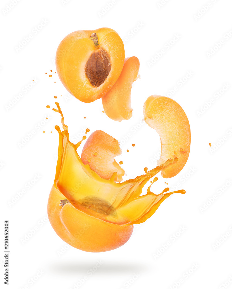 白色背景下的杏子片，果汁飞溅的特写镜头