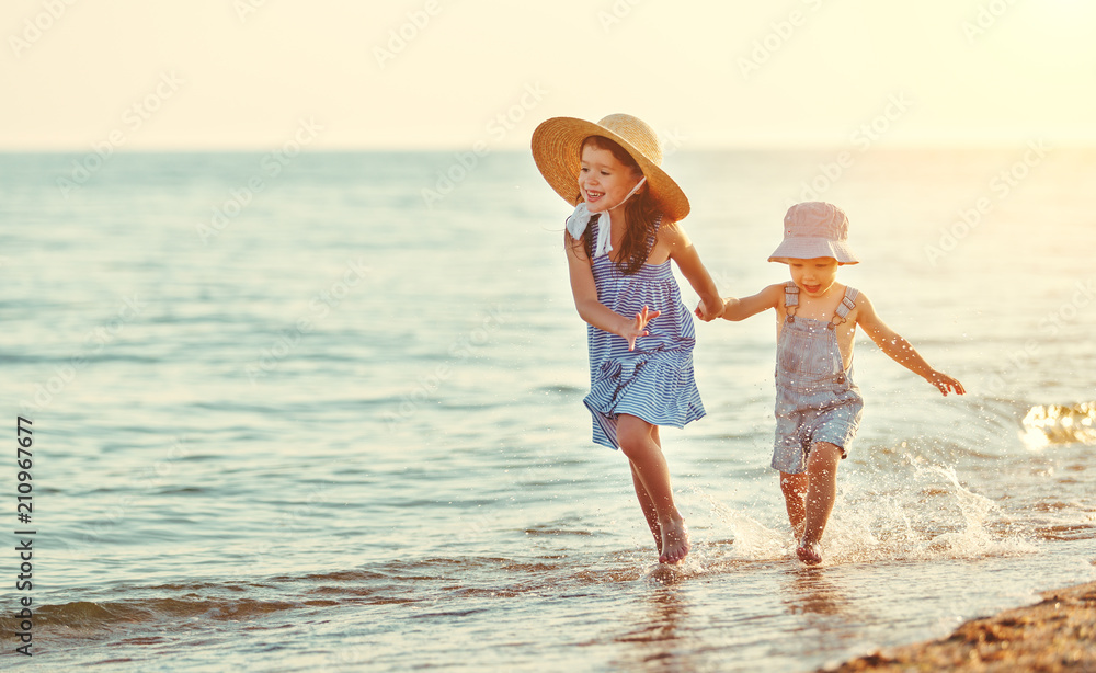 happy children walking on beach by  sea