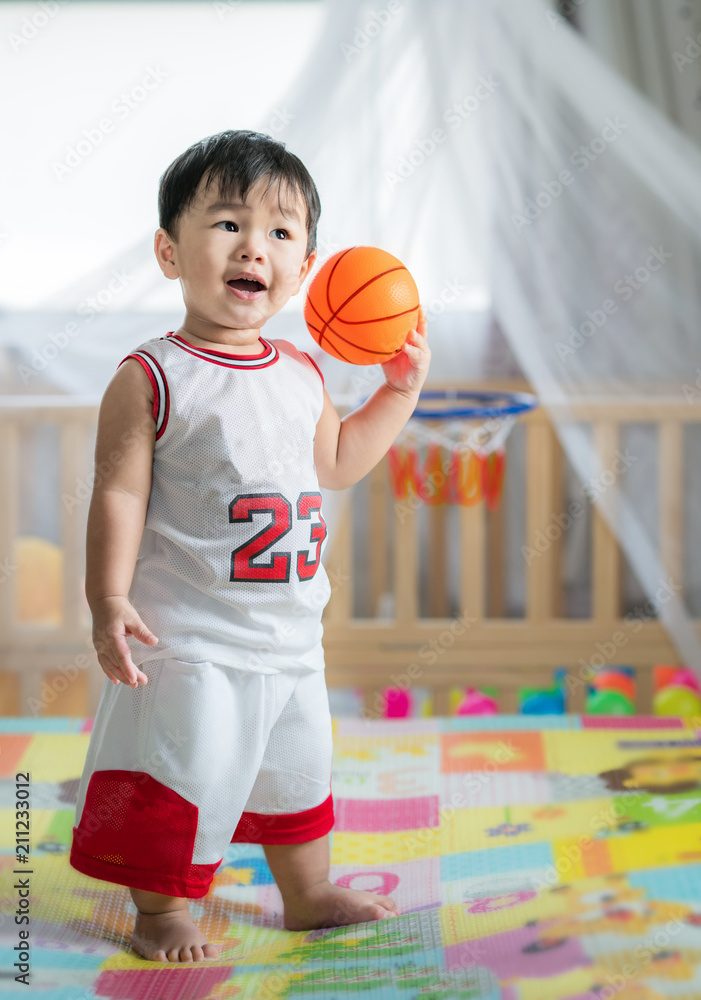 Baby with ball in basketball uniform, this immage can use for play, sport, baby, child, kid and exer