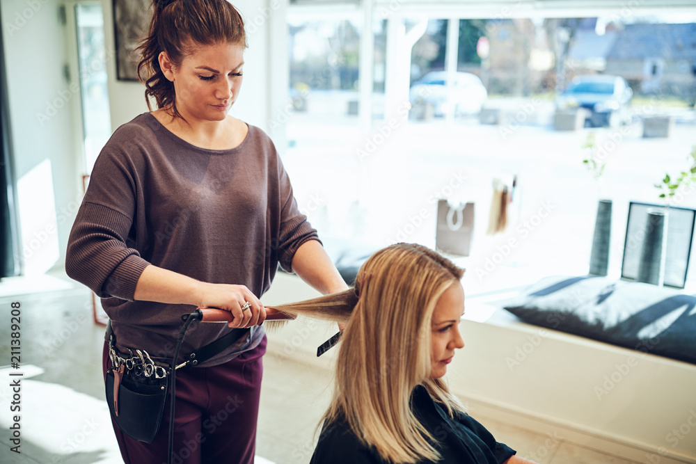 Woman sitting in a salon chair having her hair styled