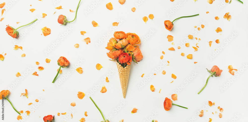 白色背景上有橙色毛茛花的华夫饼干甜筒，俯视图。春天