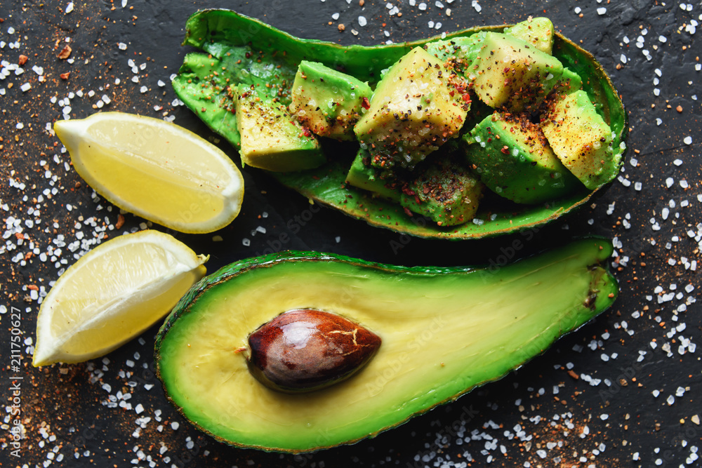 Fresh avocado fruit on a black rustic board. The concept of healthy eating. Food photography