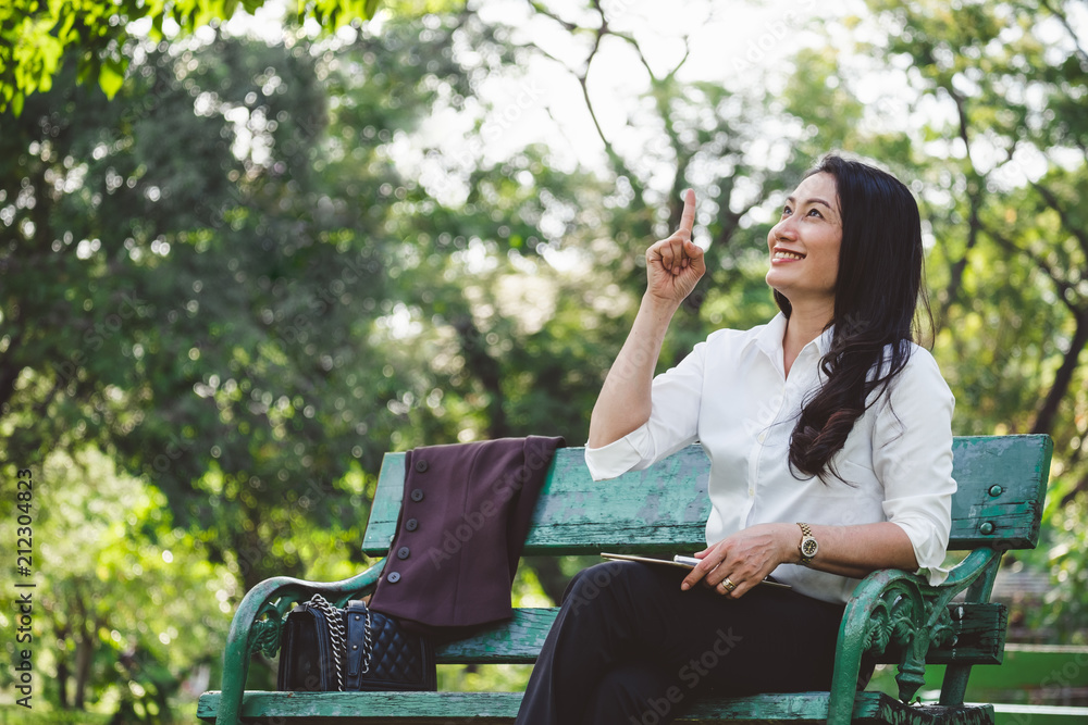 亚洲商业女性坐在有复制空间的户外公园里思考