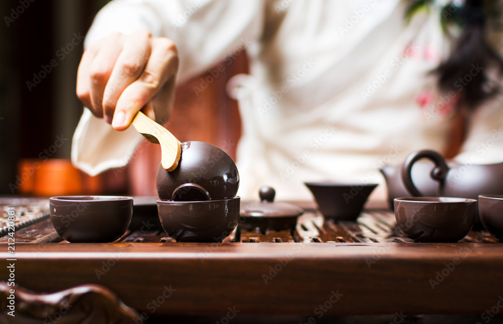 Tea ceremony, woman cleaning teacup with boiled water