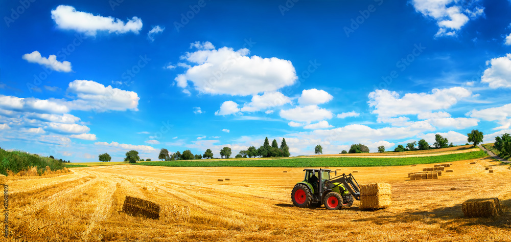 Sommer am Land: Traktor beim Laden von Stroh