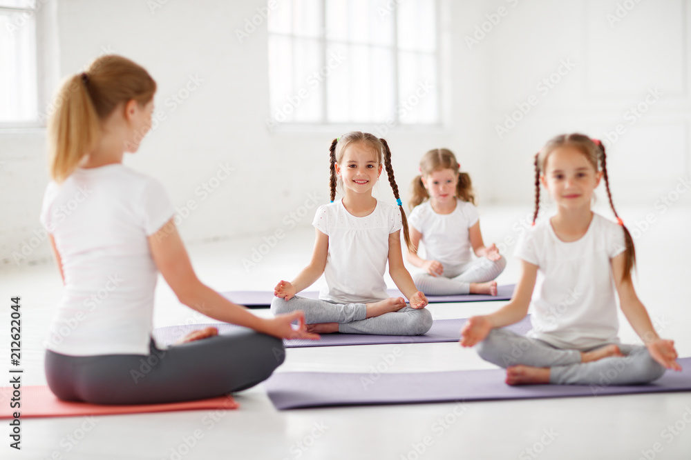 孩子们和老师一起练习体操和瑜伽。