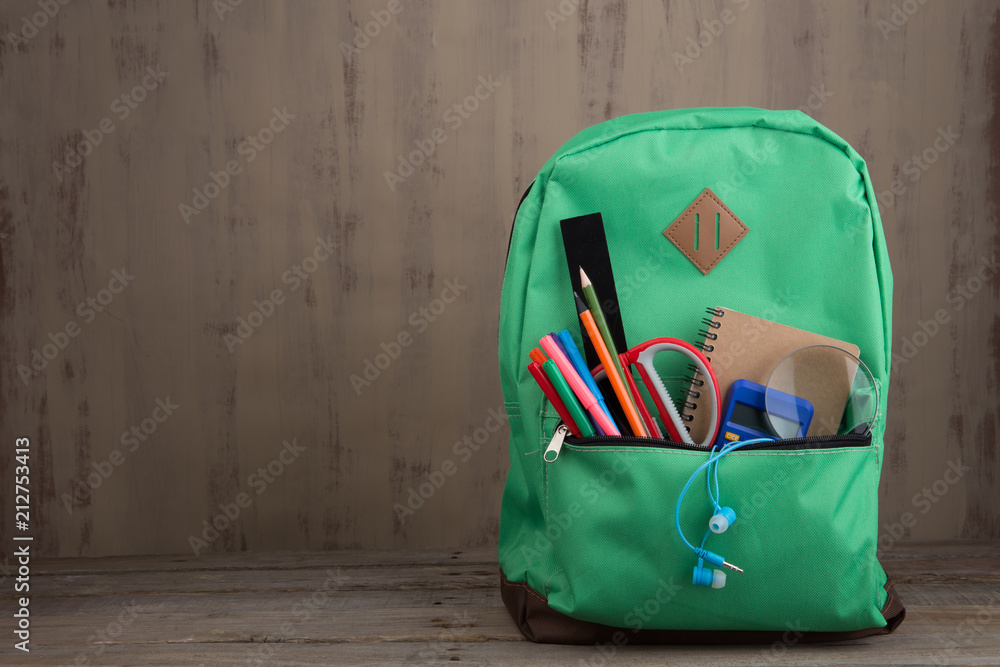 教育理念-书桌上放着书本和其他用品的学校背包