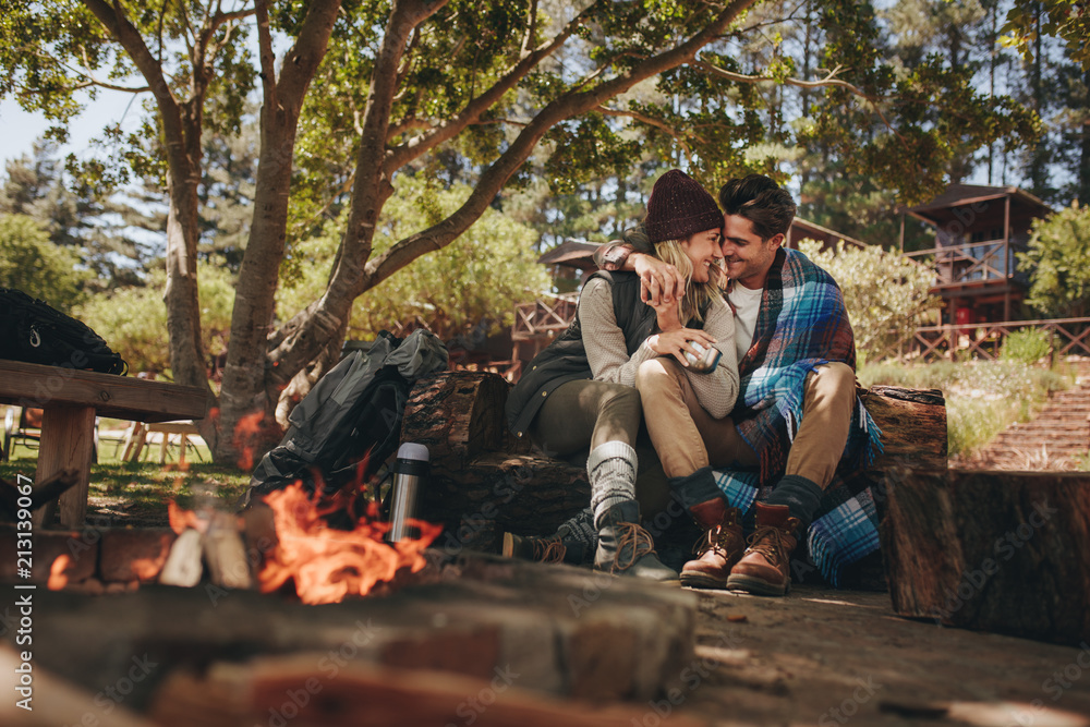 Couple in love sitting near a bonfire