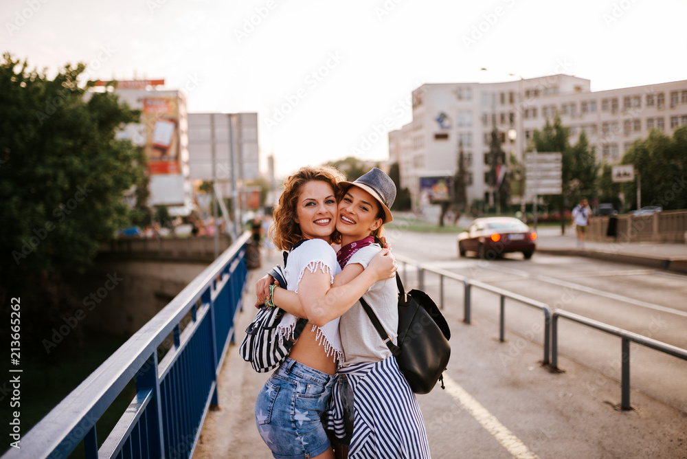 两个女朋友夏天在户外拥抱的照片。看着镜头。