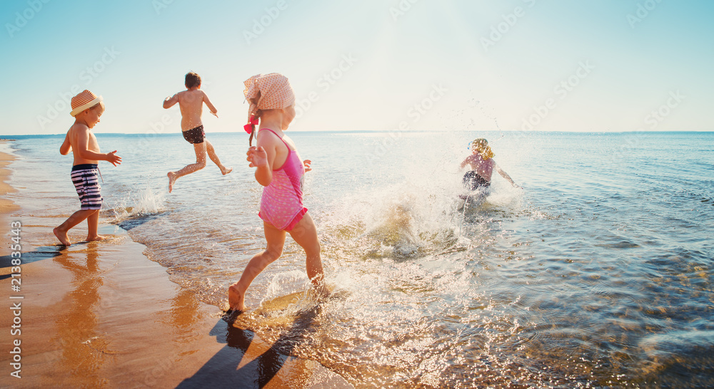 快乐的孩子们在海边度假，在水中奔跑